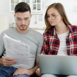 Stressed young couple looks frustrated having no money to pay off their debts