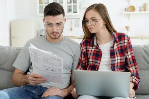 Stressed young couple looks frustrated having no money to pay off their debts